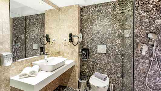 Ett badrum med en spegel, handfat, toalett och dusch. (AI-genererad text)