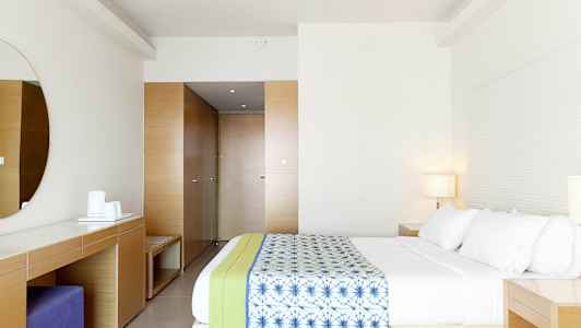 Ett modernt hotellrum med en rymlig säng och minimalistisk inredning. (AI-genererad text)