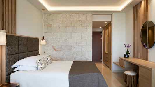 Ett modernt hotellrum med en dubbelsäng och inredning i trä. (AI-genererad text)