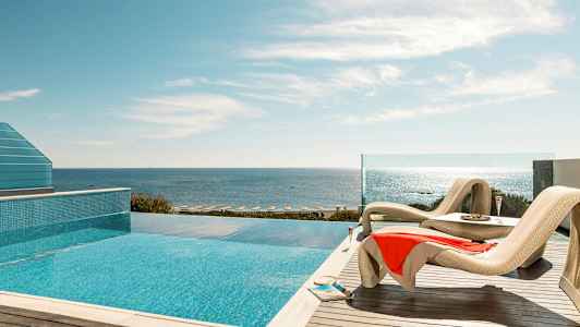Solstolar vid en pool med havsutsikt. (AI-genererad text)