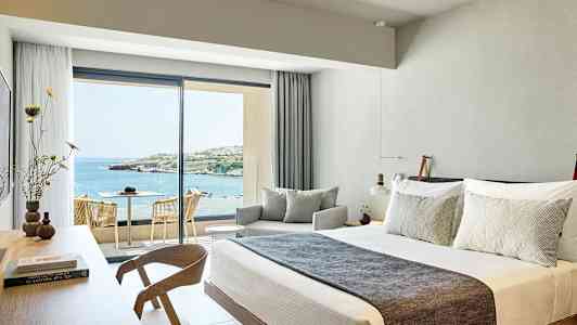 Hotellrum med modern inredning och utsikt över havet. (AI-genererad text)