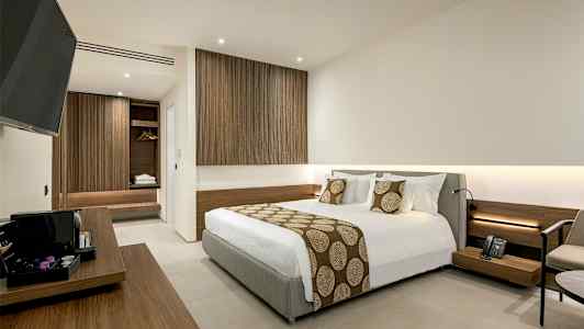 Hotellrum med modern inredning, inklusive en stor säng och trädetaljer. (AI-genererad text)