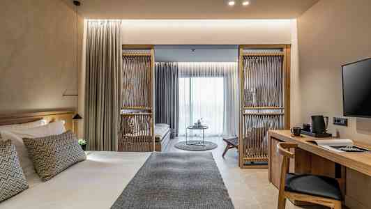 Ett modernt hotellrum med en stor säng, ett skrivbord och en sittdel. (AI-genererad text)