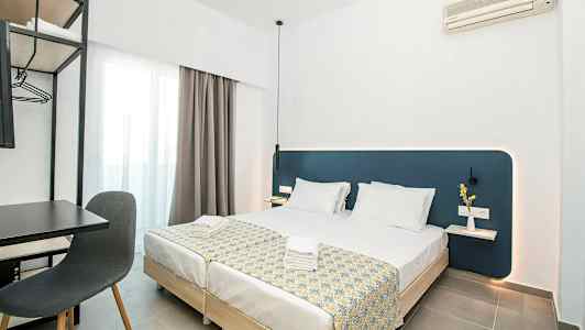 Modernt hotellrum med två bäddade enkelsängar, skrivbord och stol samt väggmonterad luftkonditionering. (AI-genererad text)