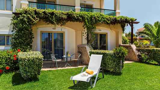 Bild av en solstol med handduk och tidning på gräsmatta framför en terrass. (AI-genererad text)