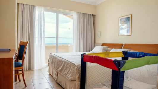 Hotellrum med dubbelsäng och barnsäng. (AI-genererad text)