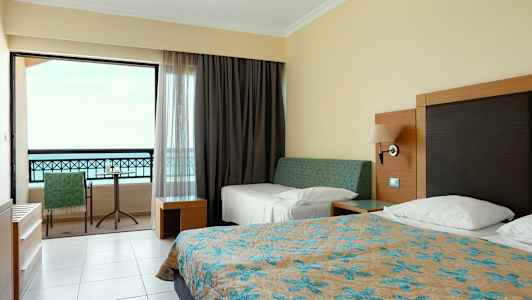 Hotellrum med sängar och balkong. (AI-genererad text)