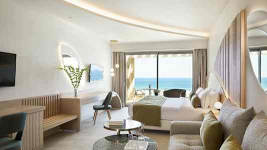 Ett hotellrum med modern inredning och utsikt över havet. (AI-genererad text)