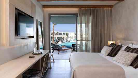 Ett hotellrum med en dubbelsäng, skrivbord och balkong mot poolområdet. (AI-genererad text)