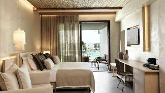 Hotellrum med dubbelsäng och utsikt över poolområdet. (AI-genererad text)