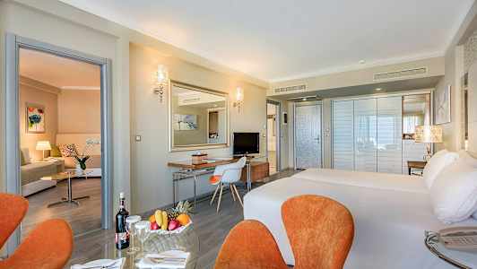 Hotelrum med dubbelsäng, sittgrupp och skrivbord. (AI-genererad text)