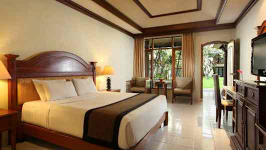 Ett välmöblerat hotellrum med en stor säng och en uteplats. (AI-genererad text)