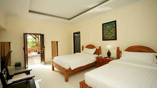 Hotellets rum med två sängar och en glasdörr som leder till en uteplats. (AI-genererad text)