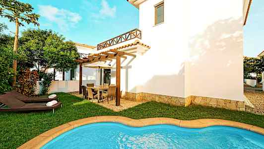 Bild av en villa med en liten pool, gräsmatta och utemöbler på en rymlig terrass. (AI-genererad text)