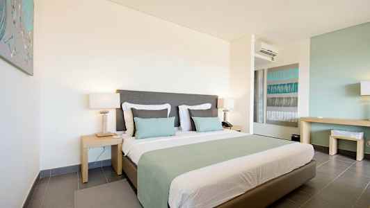 Ett hotellrum med en stor säng, två nattduksbord och modern inredning. (AI-genererad text)