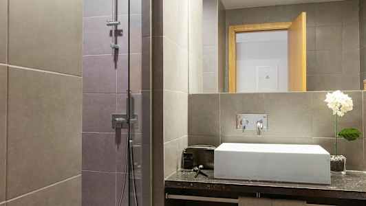 Modernt badrum med dusch och handfat. (AI-genererad text)