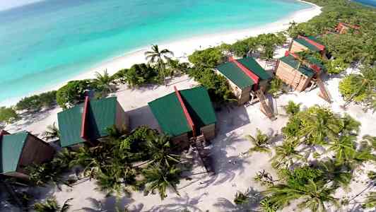 Flygbild av resort vid stranden med hav i bakgrunden. (AI-genererad text)