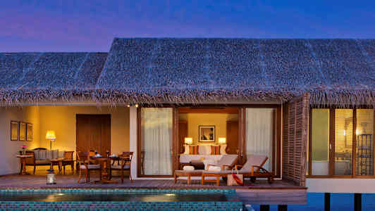 En vattenbungalow med en privat pool och möblerad terrass. (AI-genererad text)