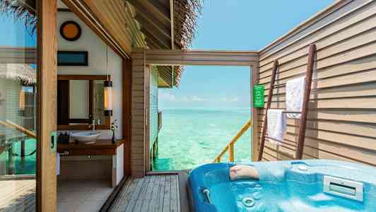 En uteplats med jacuzzi och utsikt över havet, samt en badrumsinteriör. (AI-genererad text)