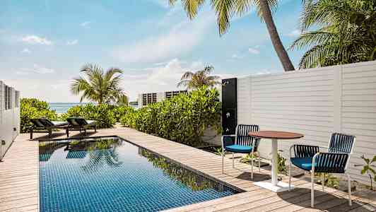 Privat pool på en terrass med solsängar och havsutsikt. (AI-genererad text)