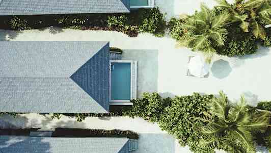 Flygbild av semesterbostäder med små pooler och grönska. (AI-genererad text)