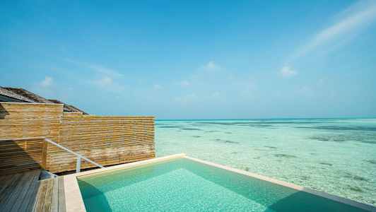 Swimmingpool vid havet med trästaket och klarblå himmel. (AI-genererad text)