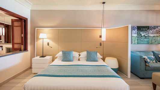 Ett modernt sovrum med en stor säng, blå prydnadskuddar och matchande bäddtextilier. (AI-genererad text)