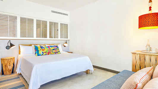 Ett rum med en säng, kuddar och en röd lampa. (AI-genererad text)