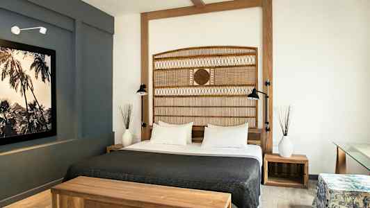 Ett hotellrum med en dubbelsäng, trämöbler och modern inredning. (AI-genererad text)