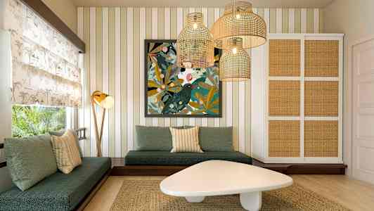 Ett vardagsrum med gröna soffor, ett konstverk på väggen och hängande lampor i rottingstil. (AI-genererad text)