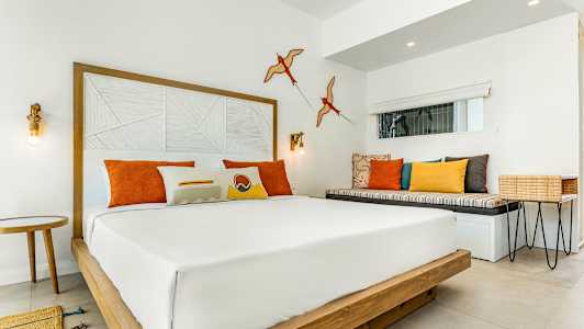 Modern hotellrum med dubbelsäng och färgglada kuddar. (AI-genererad text)