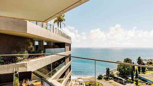 Vy från balkong med hav och park. (AI-genererad text)