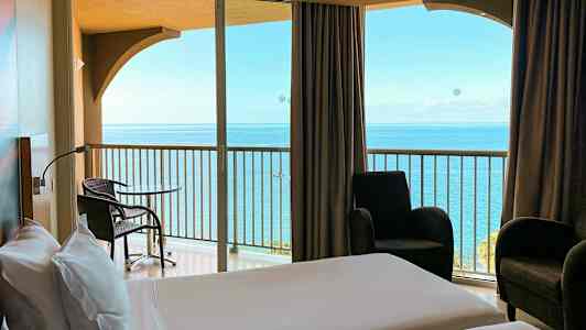 Hotellrum med utsikt över havet från balkongen. (AI-genererad text)