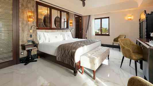 Ett hotellrum med en stor säng, sittmöbler och ett skrivbord. (AI-genererad text)