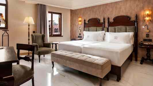 Rum med två sängar, en sittplats och fönster. (AI-genererad text)