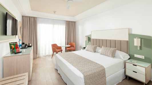 Hotellrum med dubbelsäng, tv, sittgrupp och garderob. (AI-genererad text)