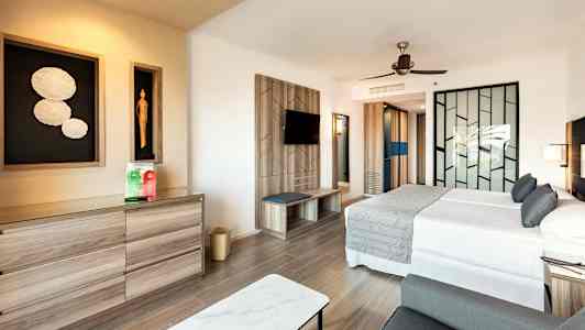 Ett modernt hotellrum med en dubbelsäng, en dekorativ vägg och en byrå. (AI-genererad text)