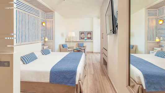 Hotellrum med dubbelsäng och stol, inrett i en ljus och modern stil. (AI-genererad text)