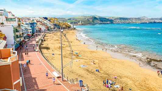 Strand med människor, hav och promenadstråk. (AI-genererad text)