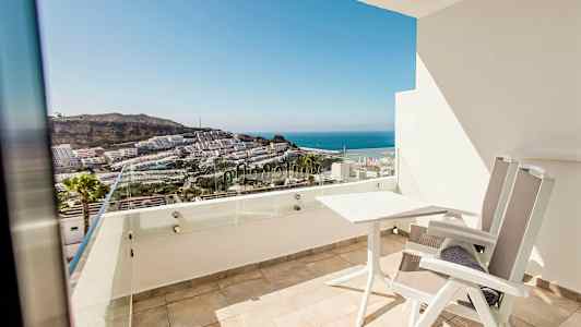 En balkong med utsikt över havet och byggnader. (AI-genererad text)