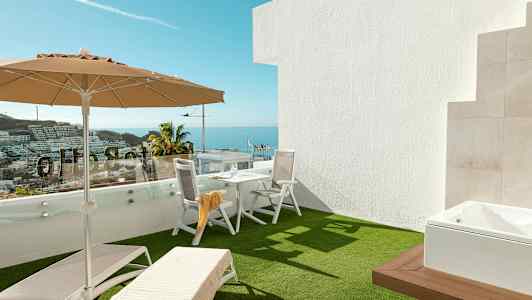Terrass med solstolar, parasoll och bord med stolar, havsutsikt i bakgrunden. (AI-genererad text)