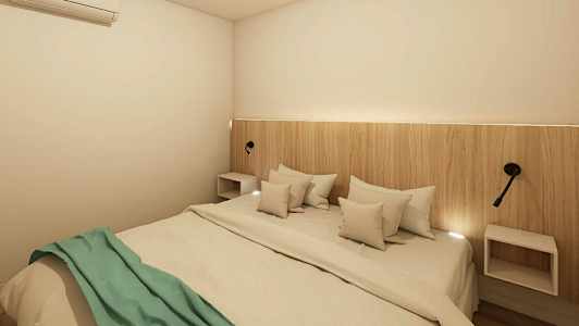 Ett sovrum med en dubbel säng, en träpanel som huvudgavel och väggmonterade lampor. Sängen är bäddad med vita sängkläder och en grön filt. (AI-genererad text)