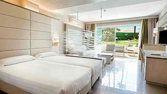 Hotellrum med två sängar och öppning mot trädgård. (AI-genererad text)