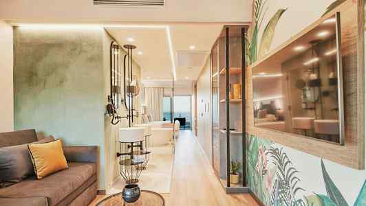 Interiör av ett stilfullt hotellrum med soffa, speglar och en TV på väggen. (AI-genererad text)