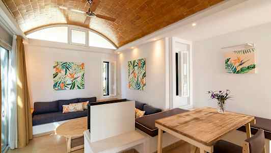 En interiör med träbord, soffa och väggdekorationer med växtmotiv. (AI-genererad text)