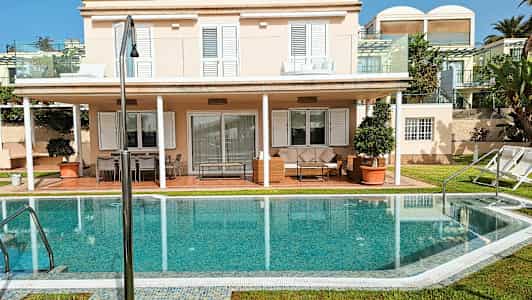 En villa med två våningar, solterrass och pool. (AI-genererad text)