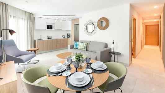 Modernt inrett vardagsrum med kök och matbord. (AI-genererad text)