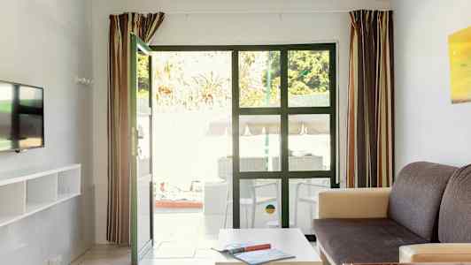 Bilden visar ett vardagsrum med öppna dörrar till en uteplats. (AI-genererad text)