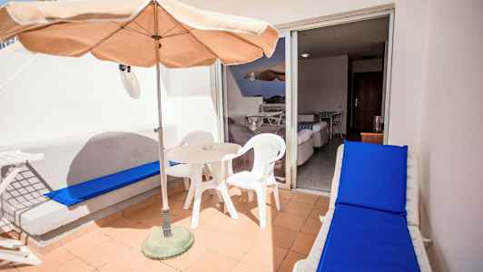 Terrass med bord, stolar och solsäng. (AI-genererad text)