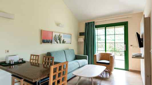 Rum med sittmöbler och matbord, avbildat med grön dörr och inredning. (AI-genererad text)